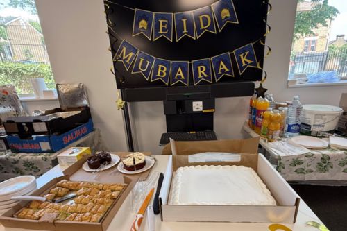 Photo of Eid al-Adha celebration Food on a table with a banner behind that says 'Eid Mubarak'